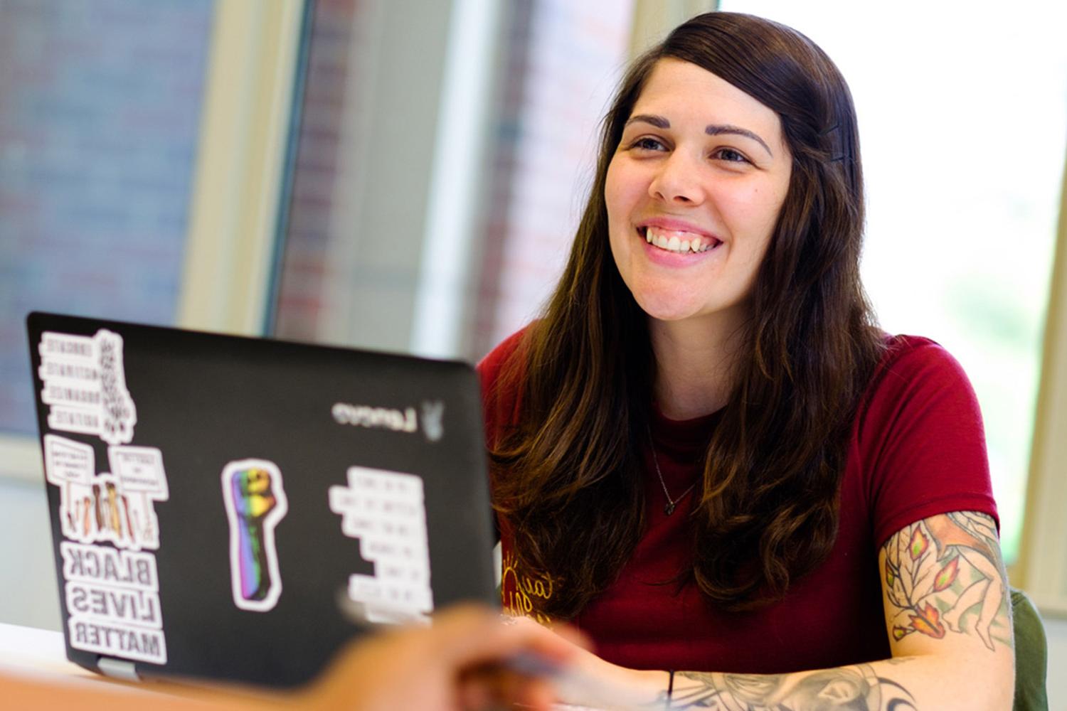 Female With Tatoos Smiling In Class